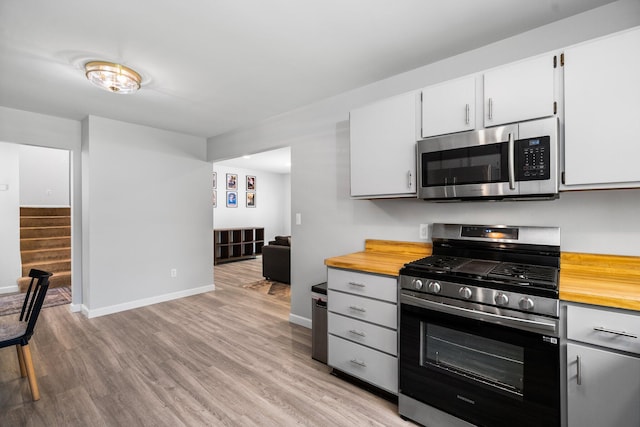 160 Cherry St, Milan, MI 48160 - kitchen with appliances with stainless steel finishes, wood counters, baseboards, and light wood-style floors