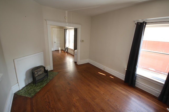 212 Rose Pl, Kalamazoo, MI 49001 - empty room featuring a wood stove, wood finished floors, and baseboards