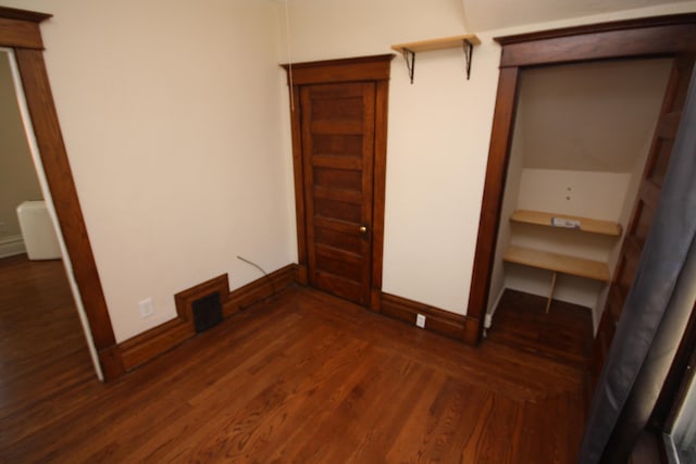 212 Rose Pl, Kalamazoo, MI 49001 - unfurnished bedroom featuring dark wood-type flooring and baseboards