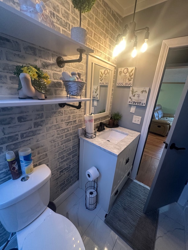 33332 Fern Ct, Lenox, MI 48048 - bathroom featuring toilet, vanity, and brick wall