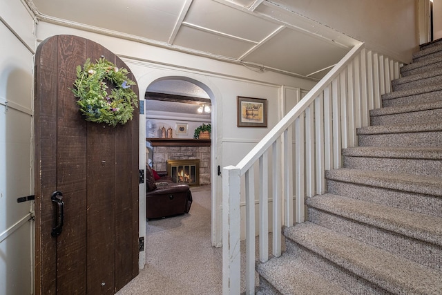 1602 Linwood Ave, Flint, MI 48503 - staircase with carpet floors, arched walkways, and a fireplace