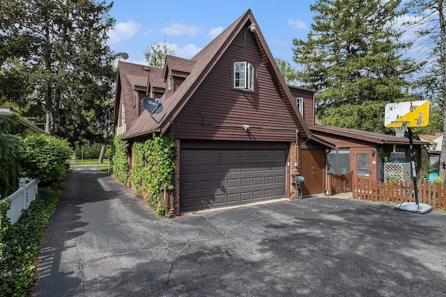 1602 Linwood Ave, Flint, MI 48503 - view of property exterior with fence, driveway, a shingled roof, and an attached garage