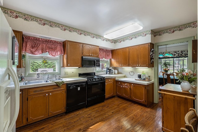 1602 Linwood Ave, Flint, MI 48503 - kitchen featuring black appliances, dark wood-style flooring, a sink, decorative backsplash, and brown cabinetry