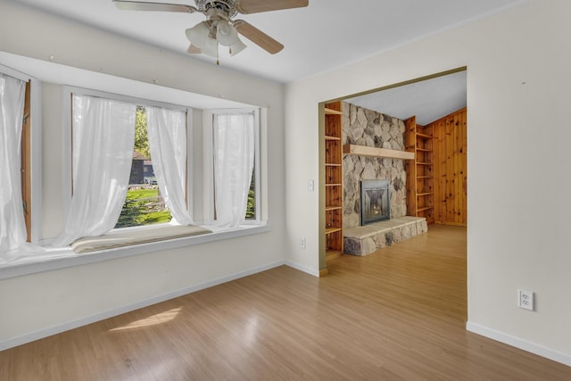 11317 N Dr, Brooklyn, MI 49230 - unfurnished living room featuring wood finished floors, baseboards, a ceiling fan, and built in shelves