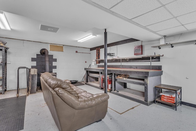 11317 N Dr, Brooklyn, MI 49230 - finished below grade area with concrete block wall, a wood stove, and a workshop area
