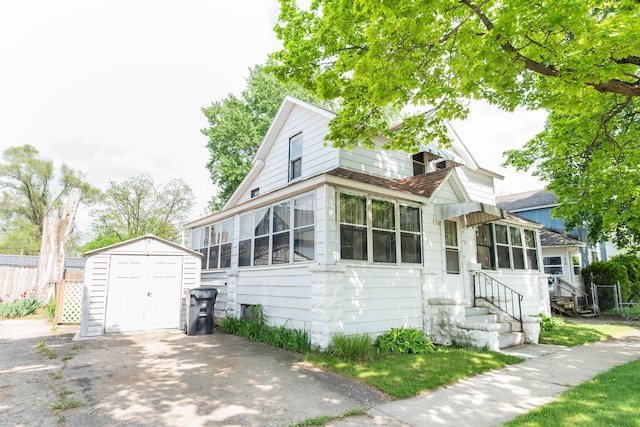 view of front of house with a storage shed, an outbuilding, fence, a garage, and entry steps