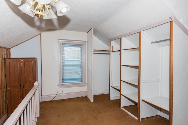 walk in closet featuring vaulted ceiling and light colored carpet