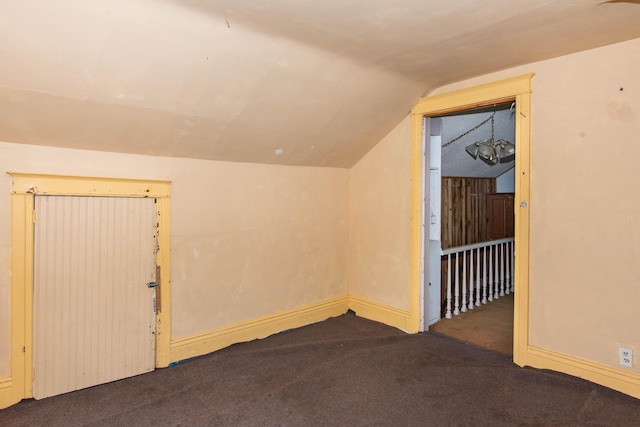 additional living space with carpet floors, vaulted ceiling, and baseboards