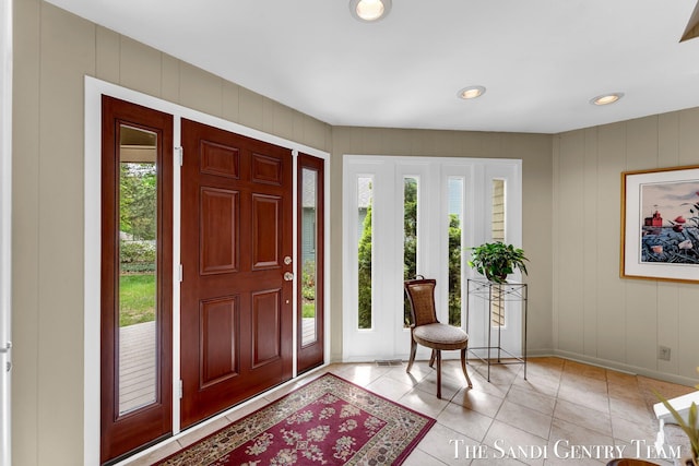 entrance foyer featuring healthy amount of natural light, baseboards, a decorative wall, light tile patterned floors, and recessed lighting