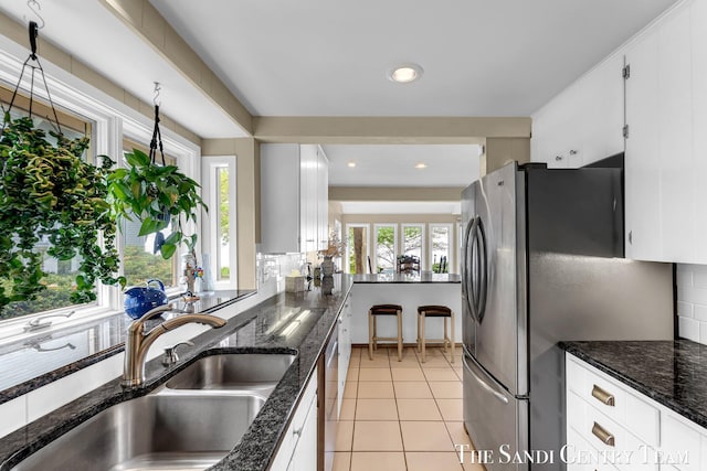 kitchen with a sink, appliances with stainless steel finishes, backsplash, healthy amount of natural light, and recessed lighting