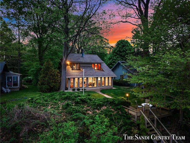 back of property with a lawn and a wooden deck