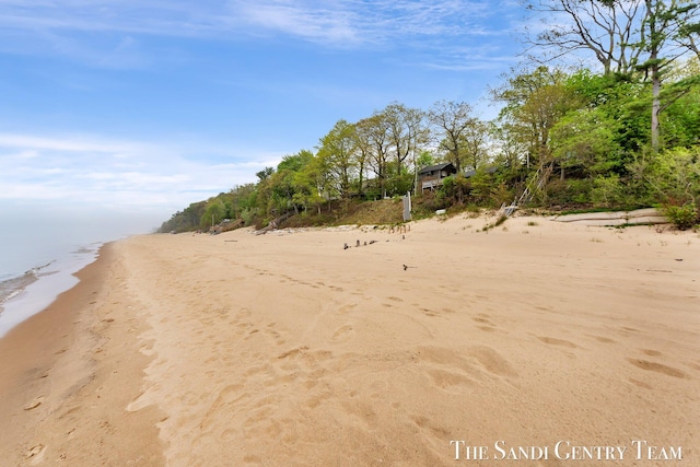 view of dirt / gravel road with view of nearby beach