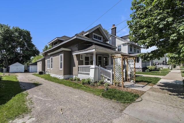 622 Thomas St SE, Grand Rapids, MI 49503 - view of front facade with covered porch, cooling unit, an outdoor structure, and a shed