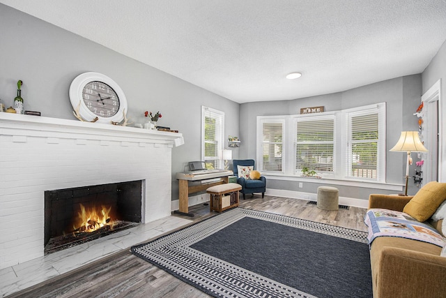 622 Thomas St SE, Grand Rapids, MI 49503 - living area featuring a fireplace, a textured ceiling, wood finished floors, and baseboards