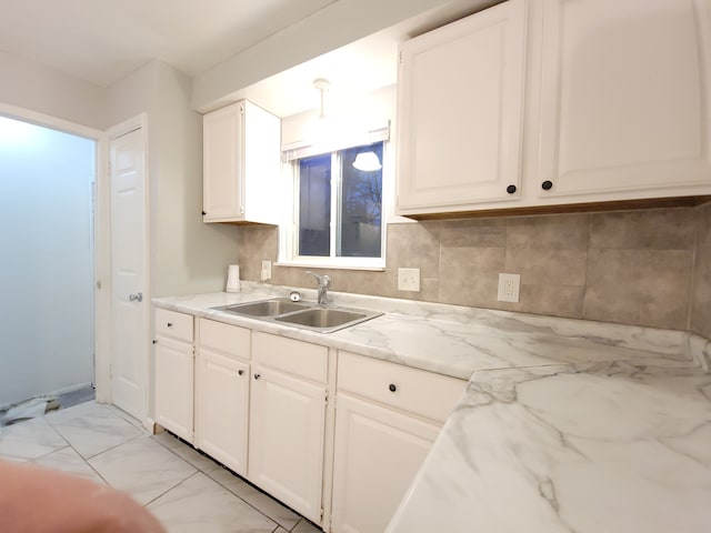 18453 Woodbine St, Detroit, MI 48219 - kitchen with a sink, light marble finish flooring, backsplash, and white cabinets
