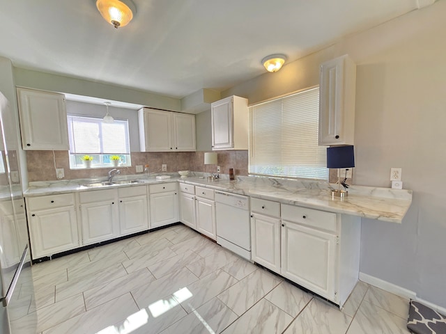 18453 Woodbine St, Detroit, MI 48219 - kitchen featuring white dishwasher, a sink, light marble finish flooring, white cabinets, and backsplash