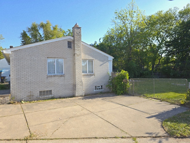 18453 Woodbine St, Detroit, MI 48219 - view of property exterior featuring fence, a chimney, brick siding, and a patio area