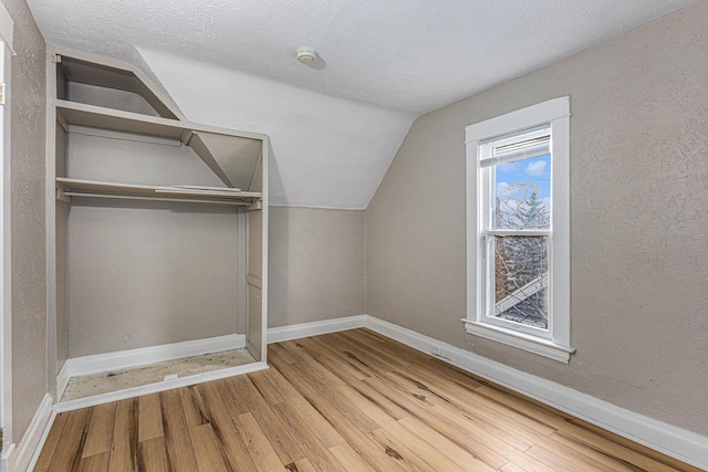 bonus room with wood finished floors, lofted ceiling, and baseboards