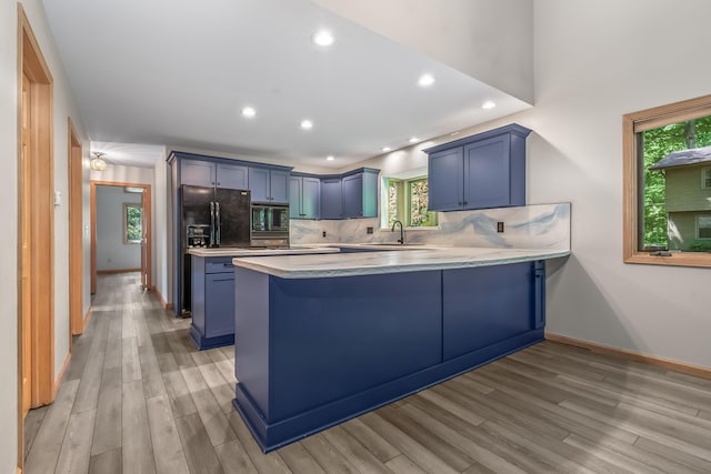 kitchen with black appliances, blue cabinets, a peninsula, recessed lighting, and light countertops