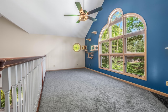 carpeted empty room featuring a ceiling fan, baseboards, and high vaulted ceiling