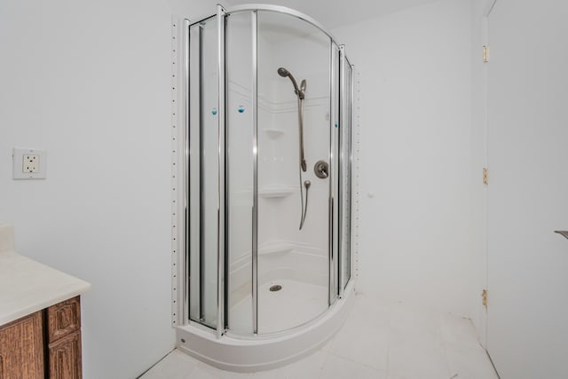 full bathroom featuring a stall shower, tile patterned floors, and vanity