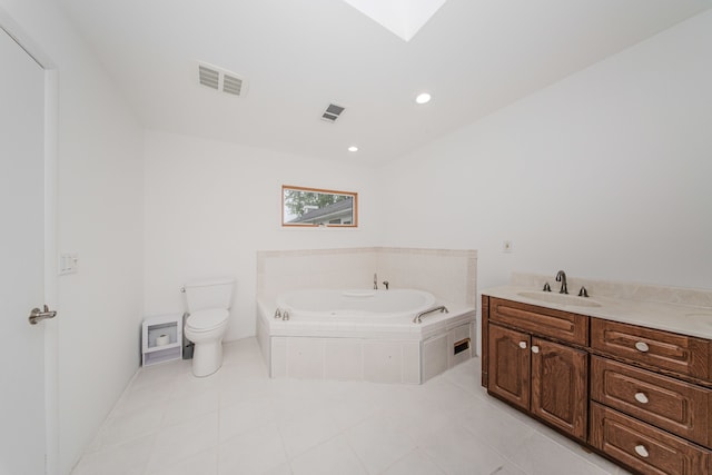 bathroom with toilet, a garden tub, vanity, tile patterned flooring, and a skylight