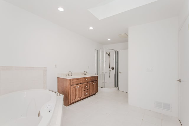 bathroom featuring a garden tub, a skylight, a shower stall, vanity, and recessed lighting