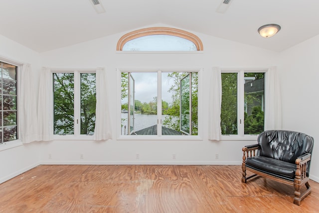 sunroom / solarium featuring vaulted ceiling, plenty of natural light, and a water view
