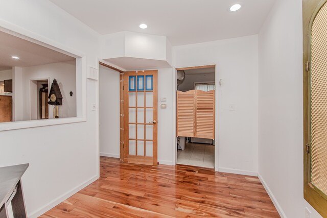 empty room featuring light wood-type flooring, recessed lighting, and baseboards