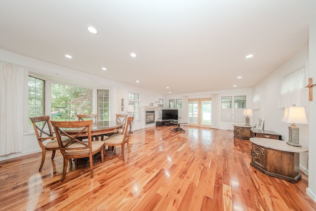 dining space featuring light wood-style flooring, recessed lighting, and a fireplace