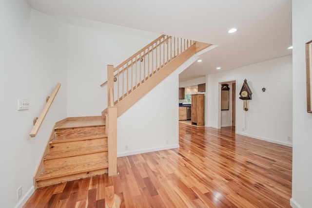 staircase featuring wood finished floors, recessed lighting, and baseboards