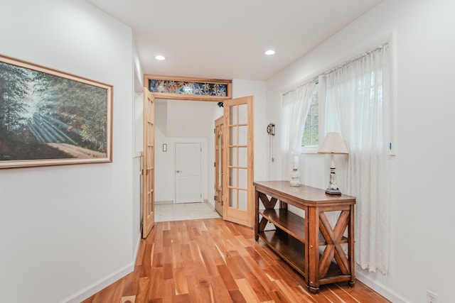 hall with light wood-style floors, recessed lighting, baseboards, and french doors