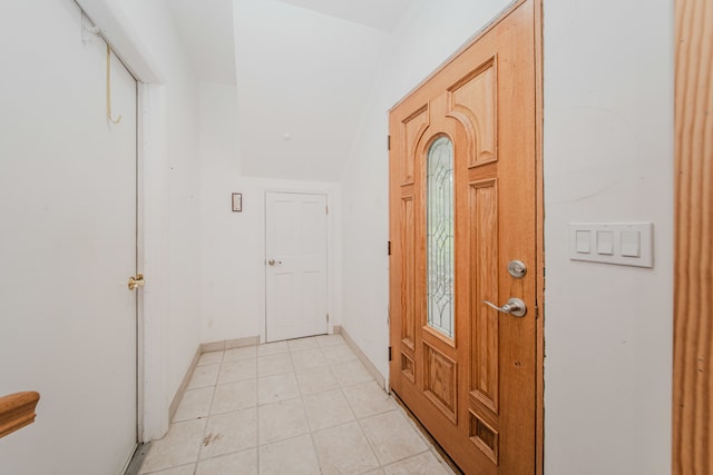 foyer entrance with light tile patterned floors and baseboards