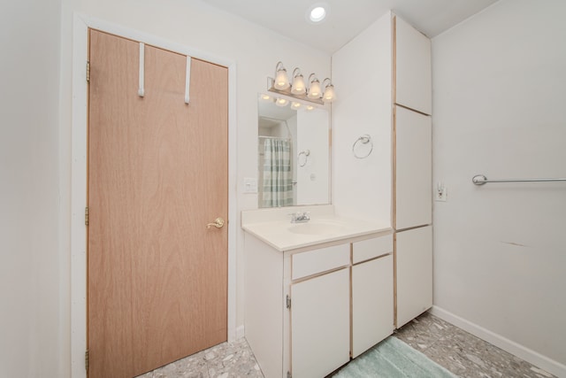full bathroom with vanity and baseboards