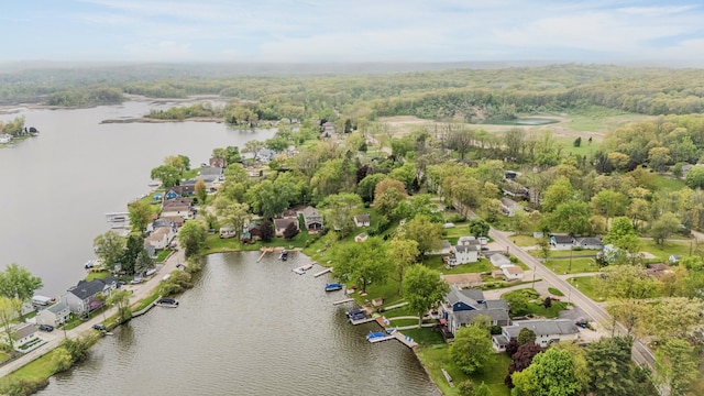 aerial overview of property's location with a nearby body of water, nearby suburban area, and a forest