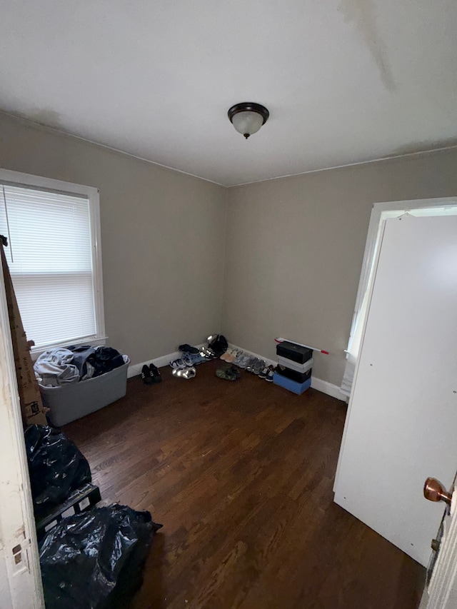 spare room with dark wood-type flooring and baseboards
