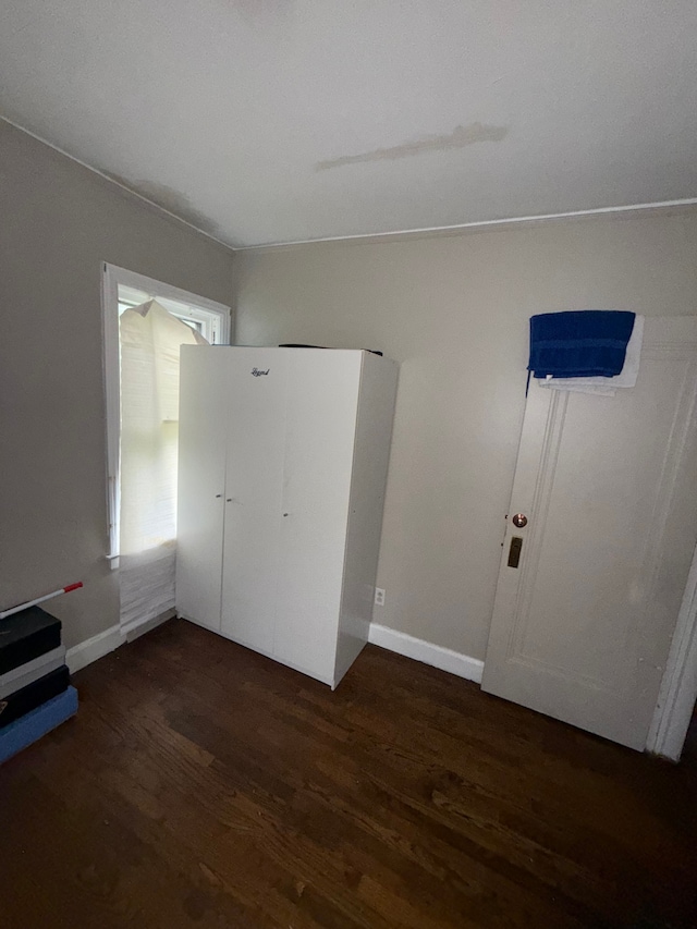 unfurnished bedroom featuring wood finished floors and baseboards