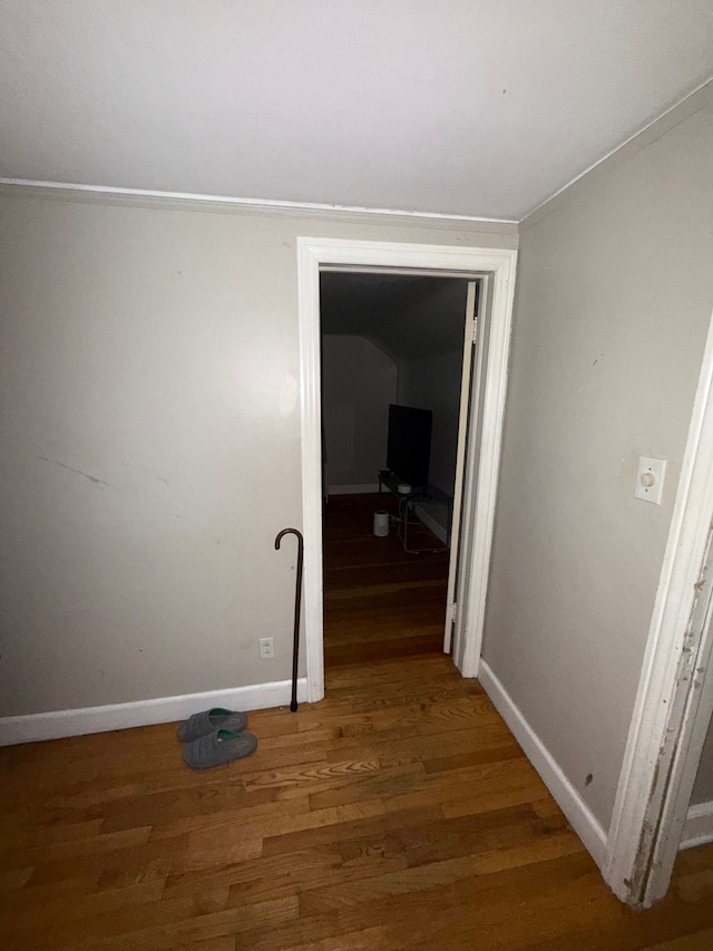 hallway featuring wood finished floors and baseboards