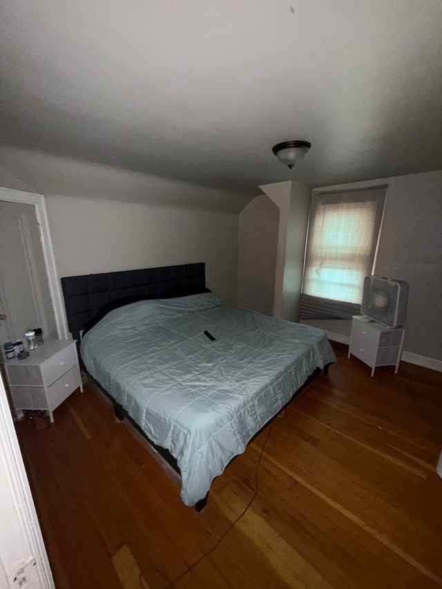 bedroom featuring wood finished floors and vaulted ceiling