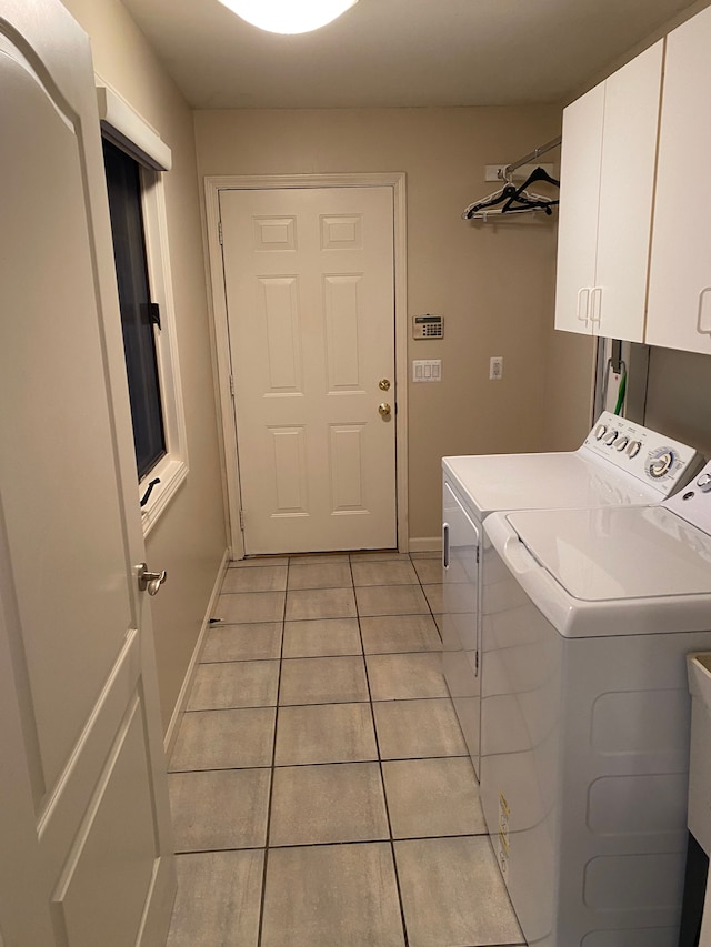 laundry area with independent washer and dryer, light tile patterned flooring, cabinet space, and baseboards