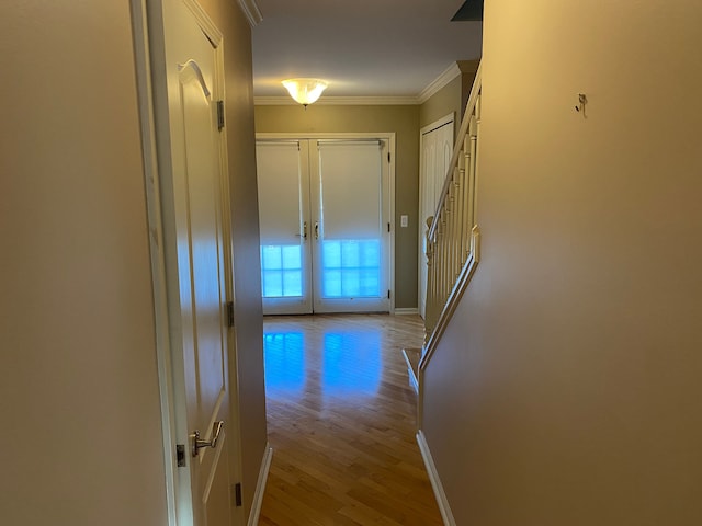 hallway with wood finished floors, baseboards, french doors, and crown molding