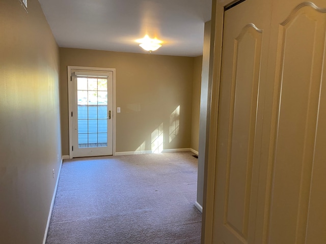 unfurnished room featuring carpet floors and baseboards