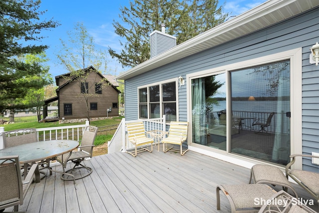 2496 Wolf Lake Dr, Baldwin, MI 49304 - wooden terrace featuring outdoor dining space and a yard