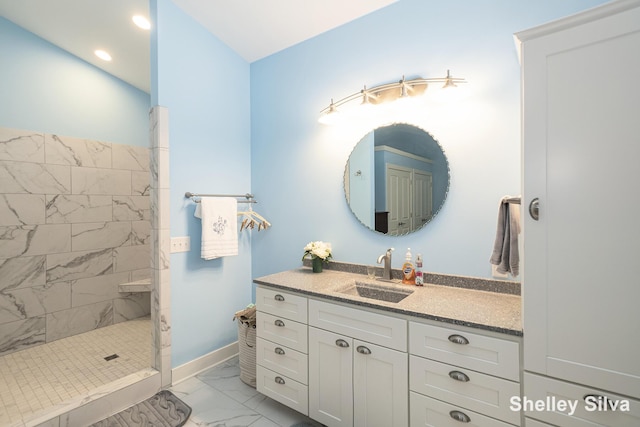 2496 Wolf Lake Dr, Baldwin, MI 49304 - bathroom with marble look tile flooring, a tile shower, vanity, baseboards, and recessed lighting