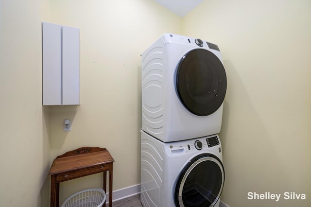 2496 Wolf Lake Dr, Baldwin, MI 49304 - washroom featuring stacked washer and clothes dryer, baseboards, and wood finished floors