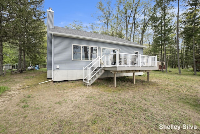 2496 Wolf Lake Dr, Baldwin, MI 49304 - rear view of house with a chimney, a wooden deck, a yard, and a shingled roof