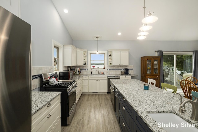 2496 Wolf Lake Dr, Baldwin, MI 49304 - kitchen featuring appliances with stainless steel finishes, a sink, white cabinets, open shelves, and vaulted ceiling