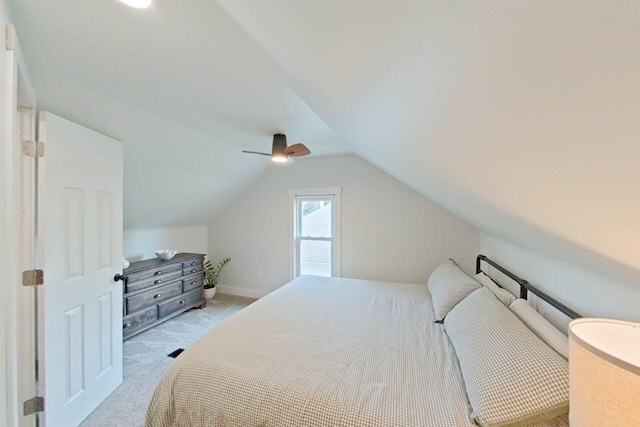 bedroom with light colored carpet, vaulted ceiling, ceiling fan, and baseboards