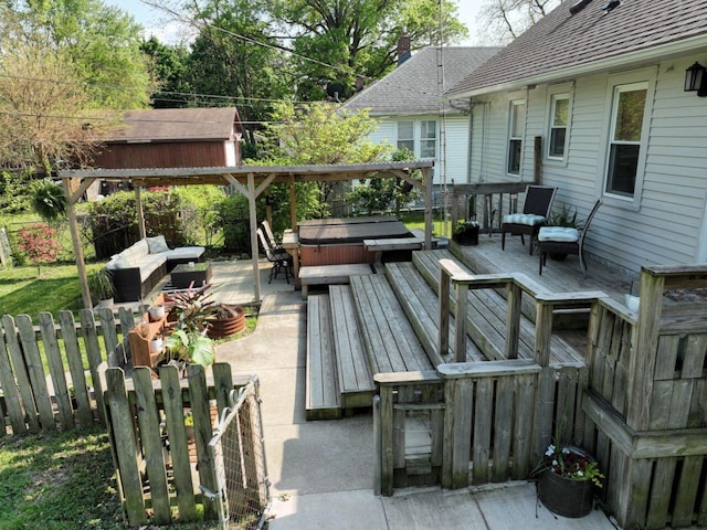 wooden terrace with a hot tub, a fenced backyard, and a patio