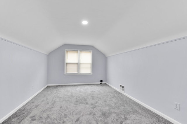 bonus room with lofted ceiling, carpet flooring, and baseboards